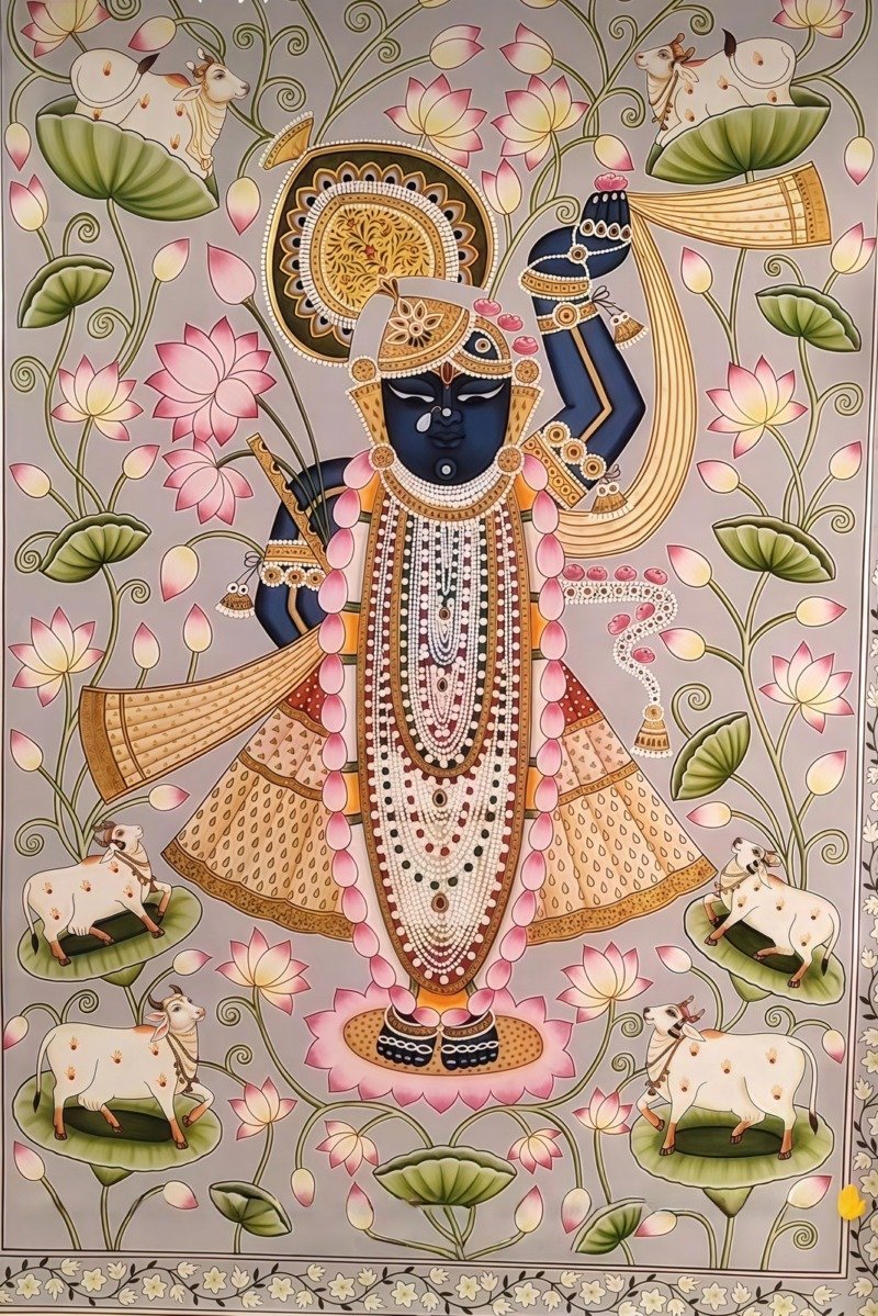 Pichwai painting of Shrinathji surrounded by pink lotus vines and white cows on a grey background