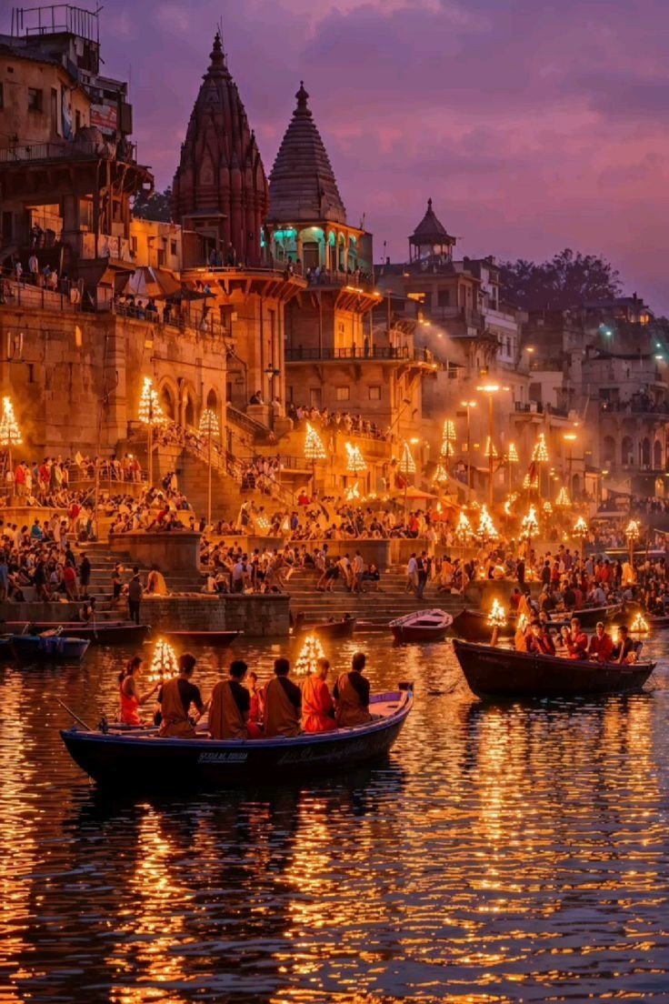Varanasi ghats at dusk with glowing lamps, temple spires, crowds and boats on the Ganga river